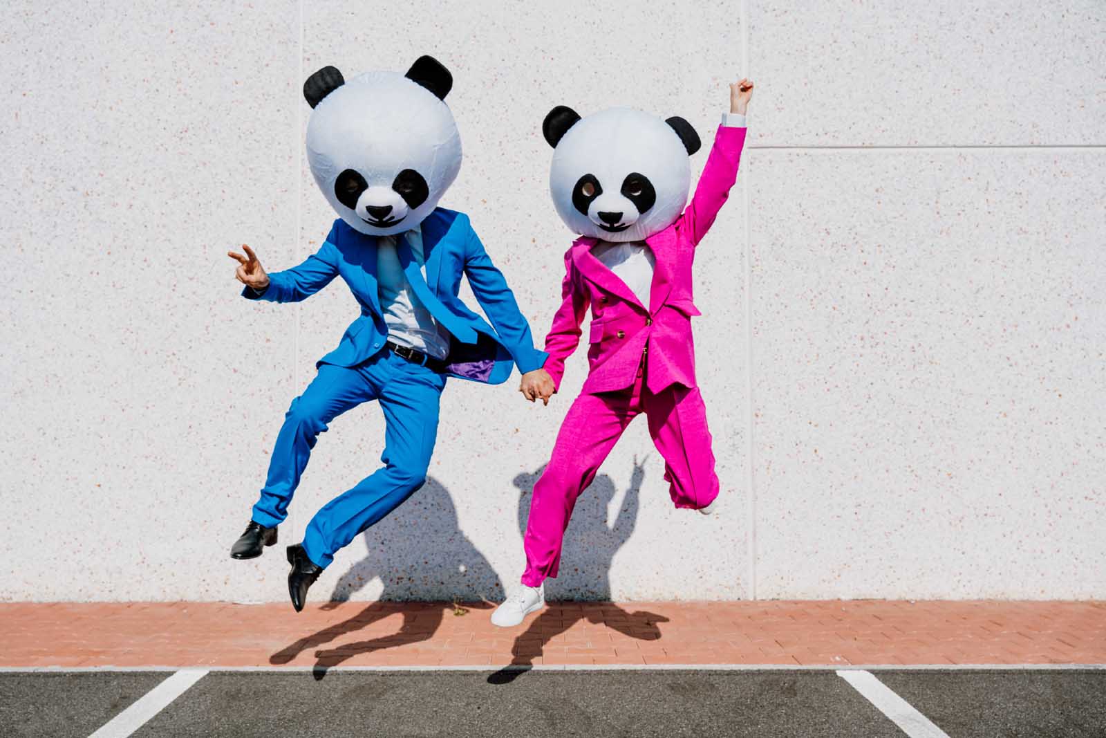 2-People-In-Colorful-Suits-Jumping-With-Panda-Mask-Vector-X